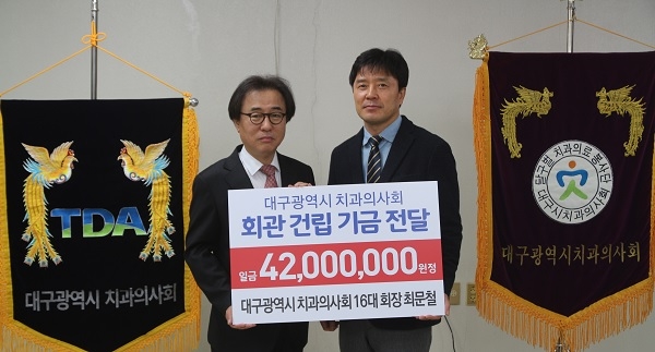 최문철 회장(왼쪽)이 이기호 신임회장에게 건립기금을 전달했다.
